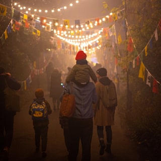 Family walking through a lighted woodland trail