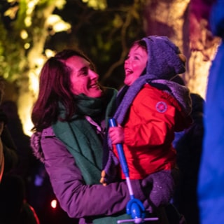 Mother and child with happy faces as they look on at a light show